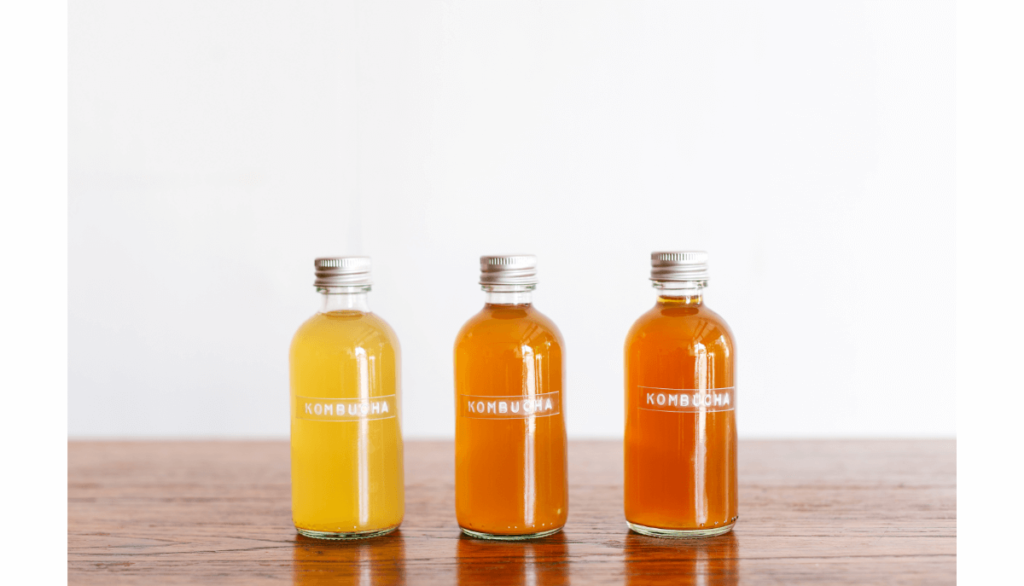 Three bottles with kombucha written on them